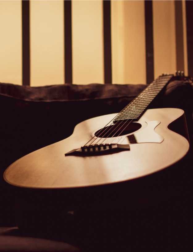 A guitar laying on a couch.