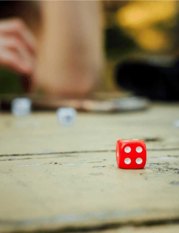 A red dice on a table.