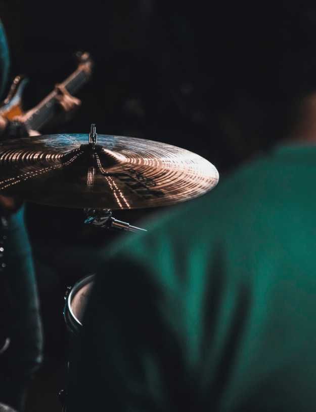 Back view of Someone playing the drums.