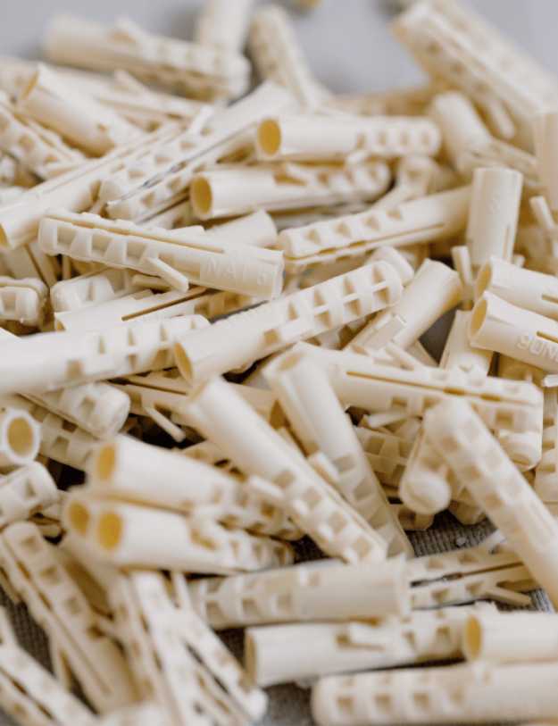 A pile of white drywall anchors.