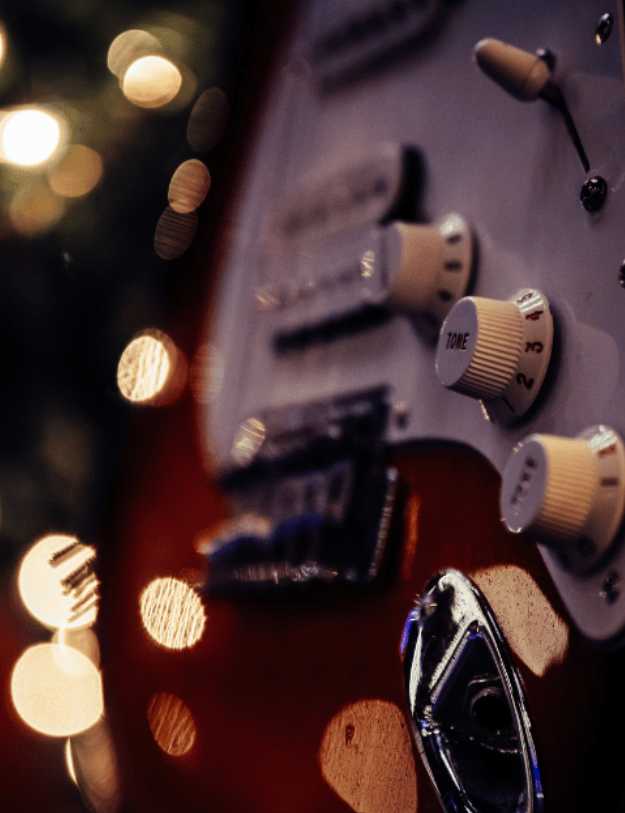 Close up of a red and white guitar.