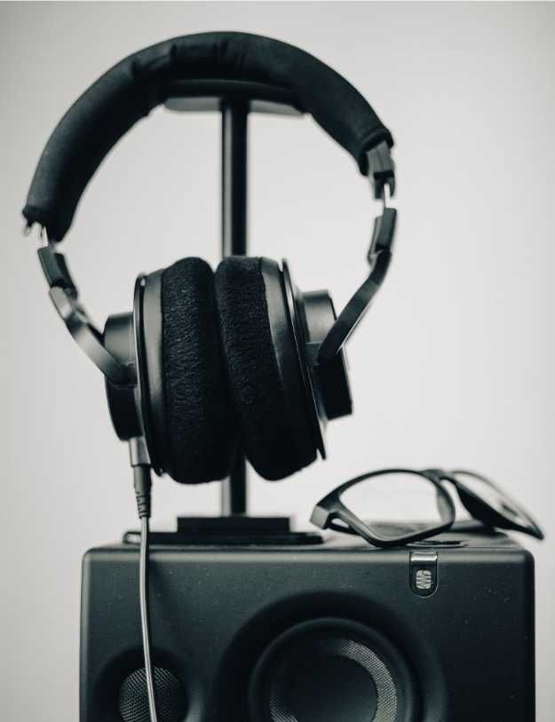 Headphones on top of a speaker.