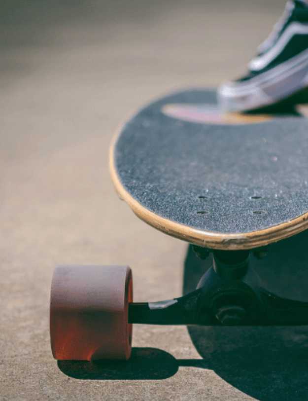 A longboard being stepped on at a skate park