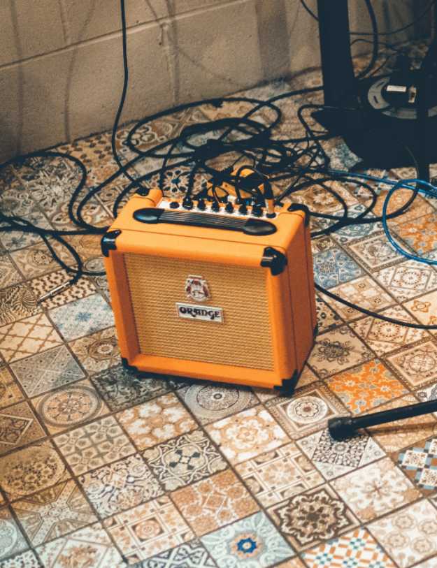 A mini amp on a floor with colorful tile.