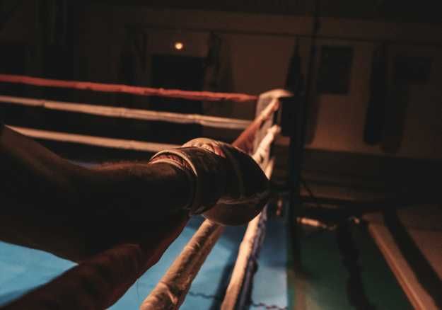 Boxer resting arm on boxing ring