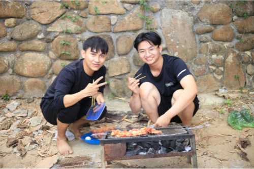Young men cooking on small griddle grill