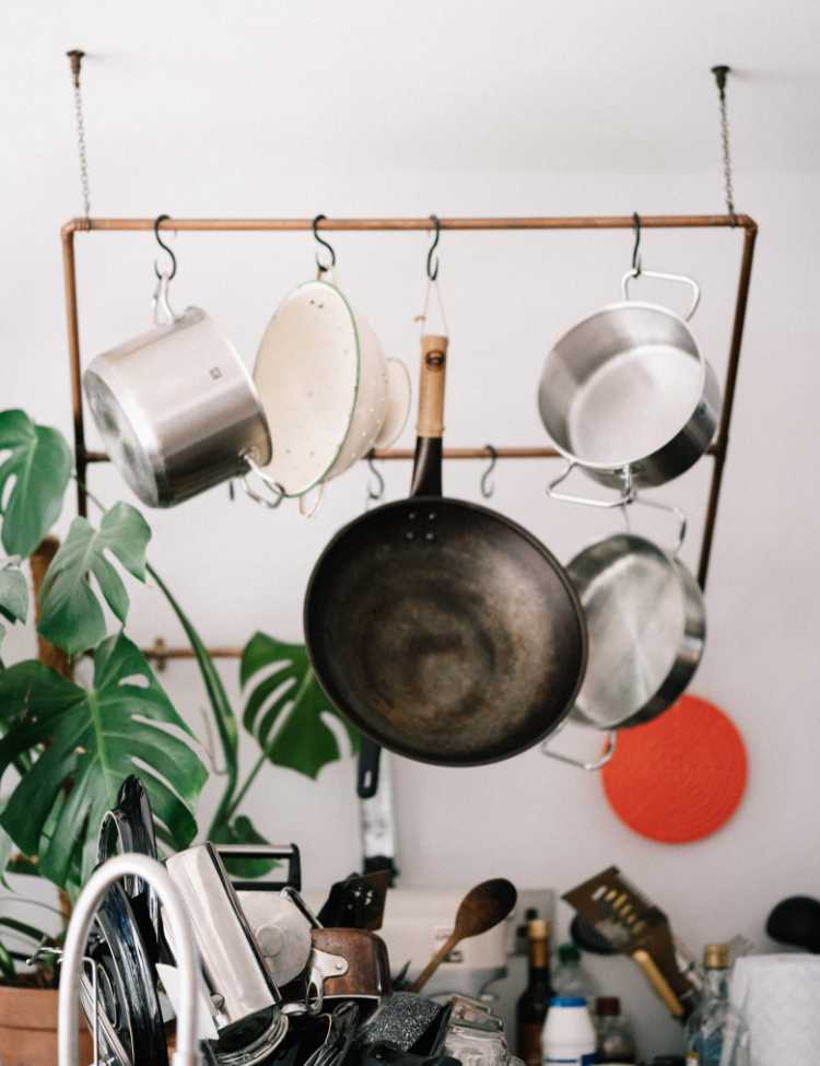 Clean pots and pans hanging in kitchen 
