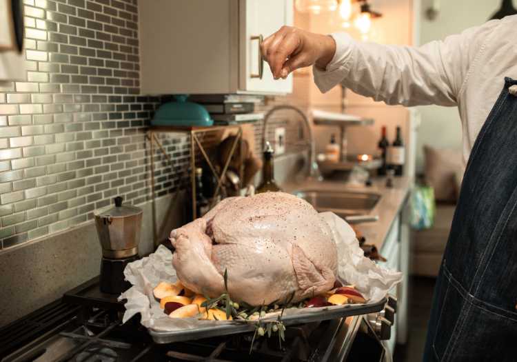 Chef seasoning a whole turkey, preparing for the smoker!