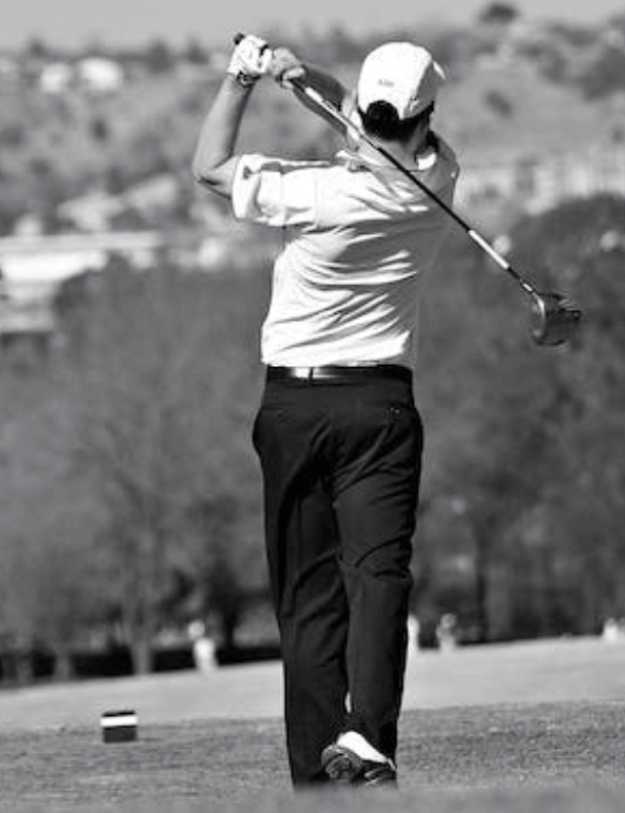 A black and grey photo of a middle age man swinging a golf club