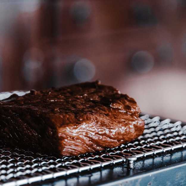 A Juicy steak on a wire tray.