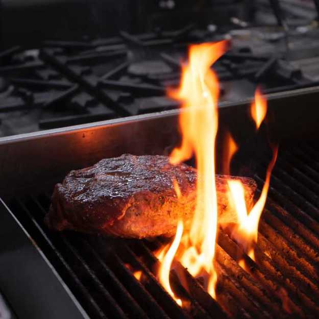 A Steak in a corner of a grill.