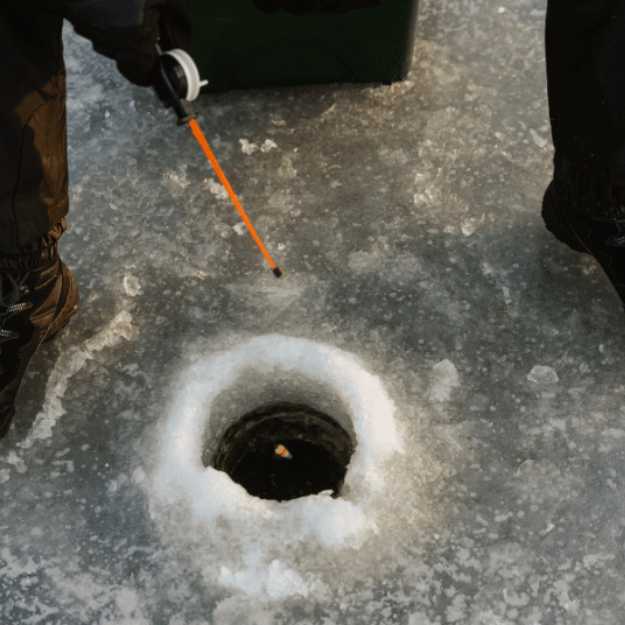 Someone ice fishing with a small fishing rod.