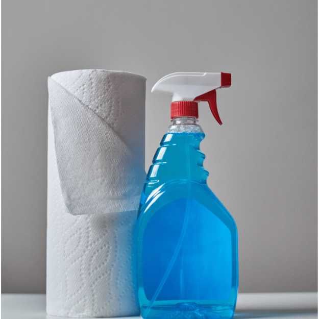 A  Spray bottle next to a roll of towels.