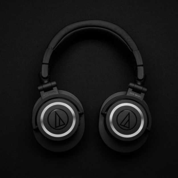 Black headphones on a black surface.