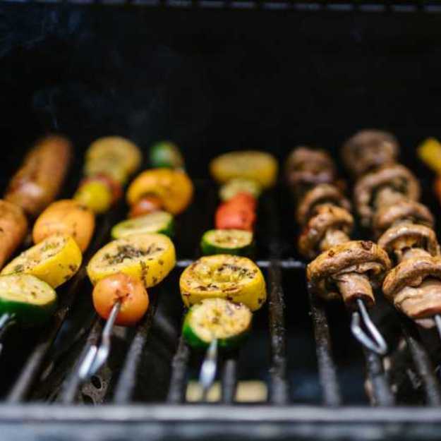 A bunch of kebabs on a grill.