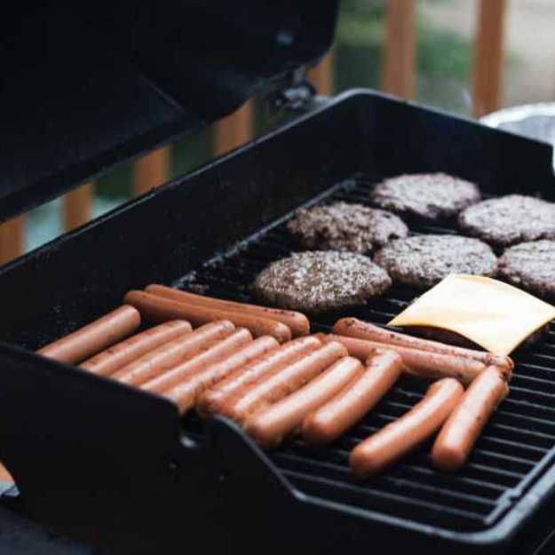 Hot dogs and burger patties being grilled.