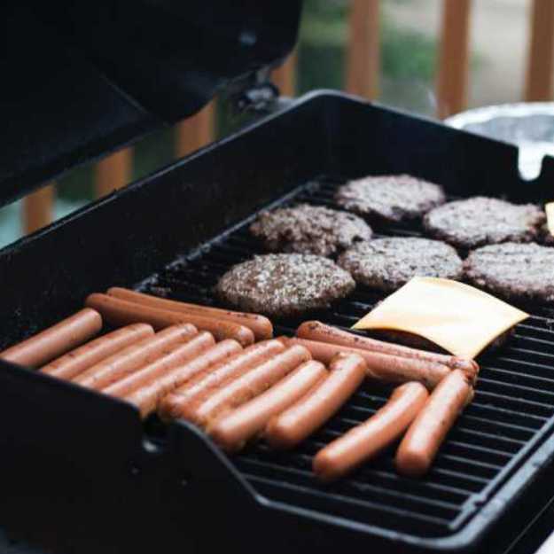 Hot dogs and burger patties being grilled.