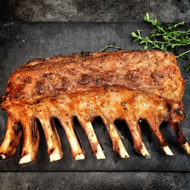 Crispy lamb chops on a tray outside.