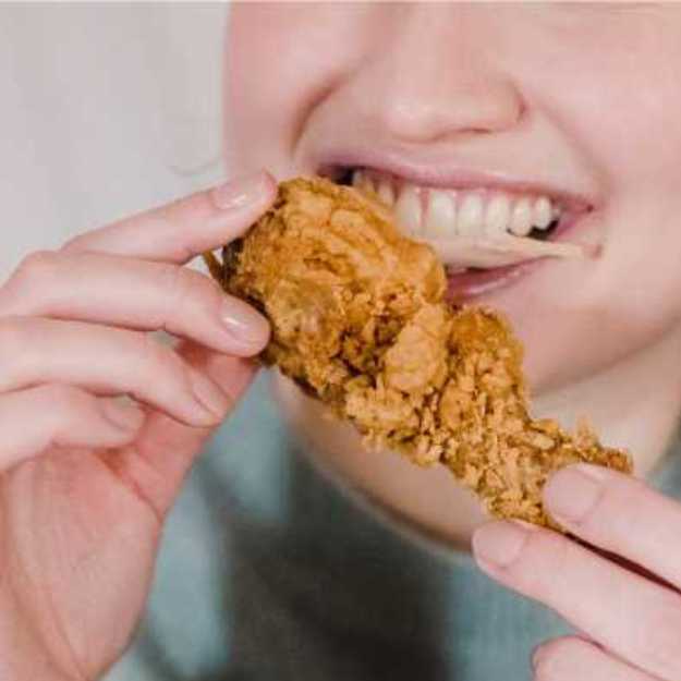 Someone eating fried chicken with both hands.