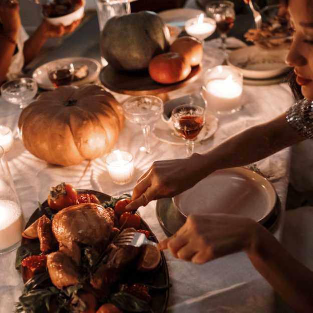 A Woman carving a turkey during a celebration.