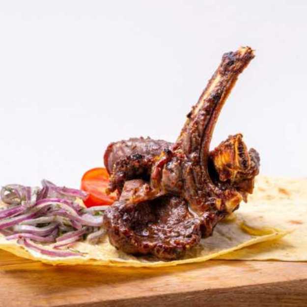 Lamb chop with onions on the side.