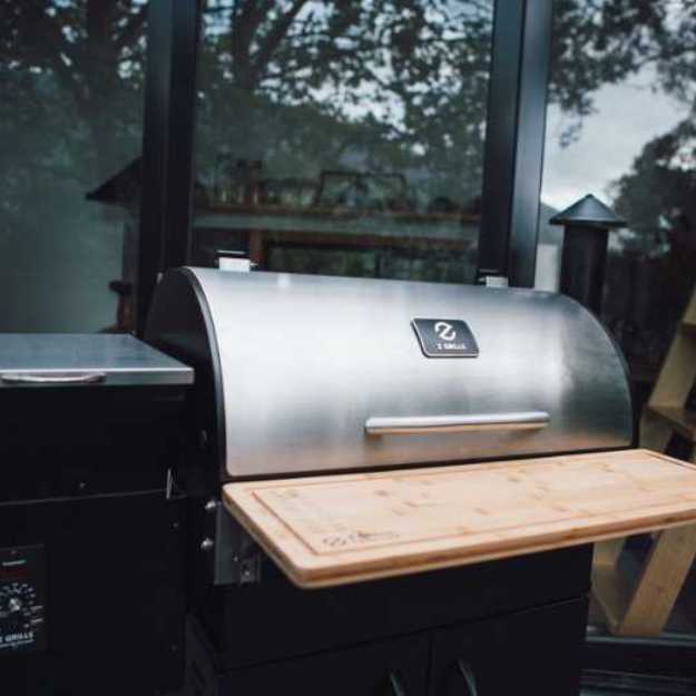 A Closed grill with a cutting board attached to its front.