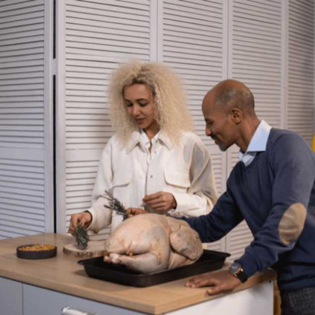 A Couple preparing a raw turkey for a feast.