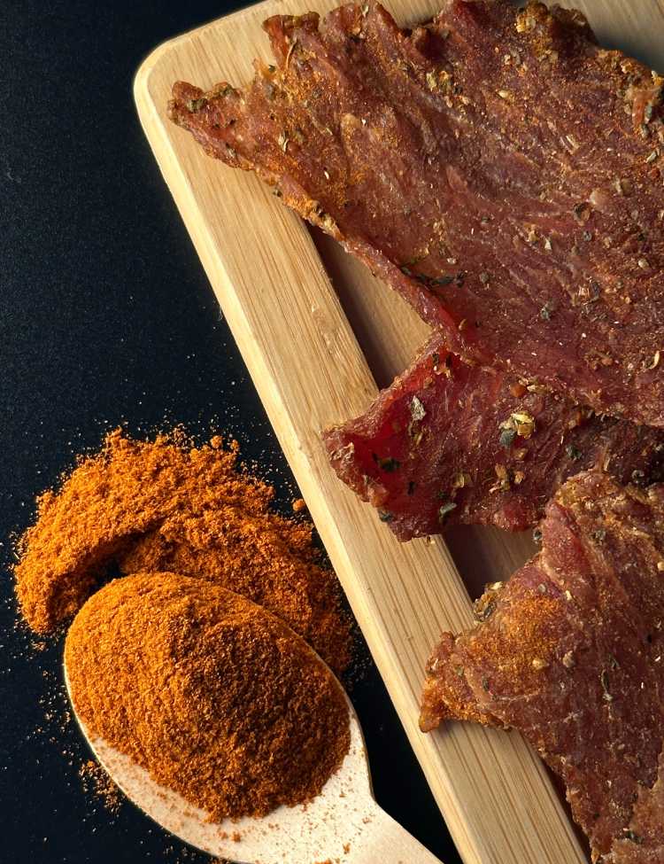 Seasoning on a spoon next to beef jerky