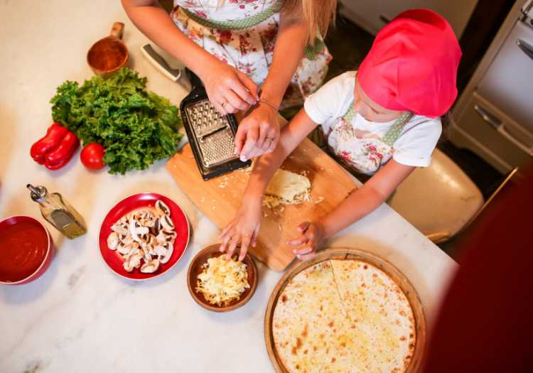 A mother and daughter making grilled pizza