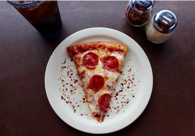 1 slice of pizza on a plate, ready to eat!