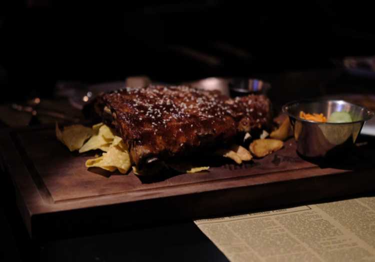 Slab of pellet smoked pork ribs on a wooden cutting board, ready to be served!