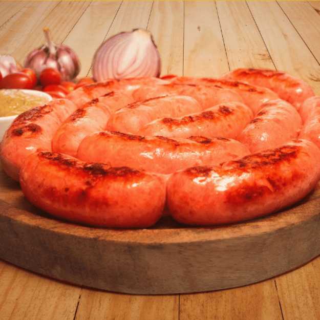 A swirled sausage on a circle cutting board.