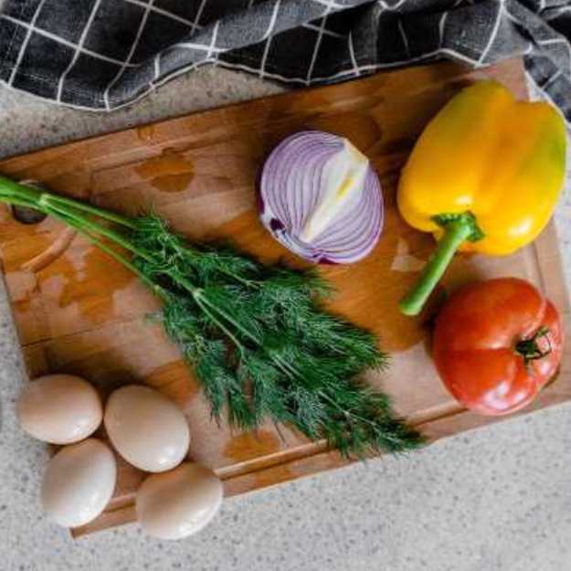 Eggs and veggies on a cutting board.