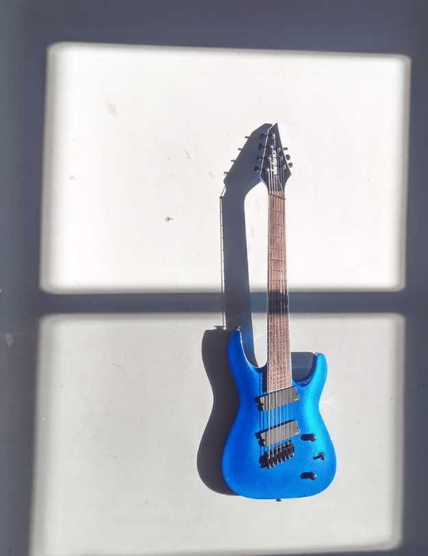 A blue guitar on a cement floor.