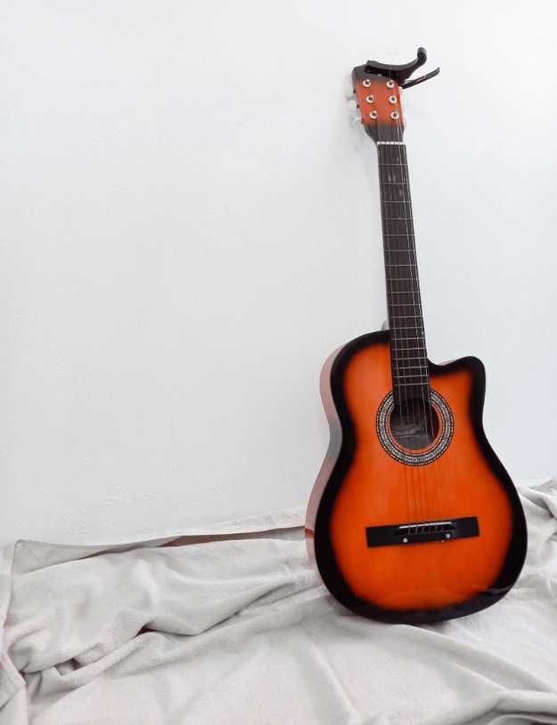 A guitar on someones bed.