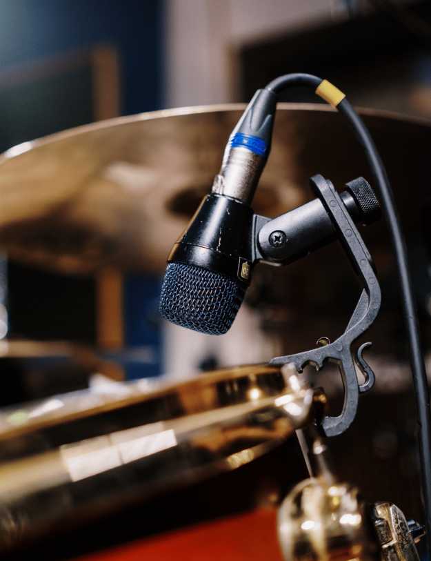 A microphone standing next to a cymbal.