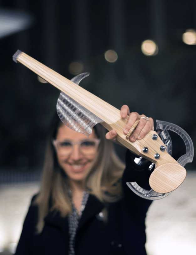 A woman holding up her electric violin.