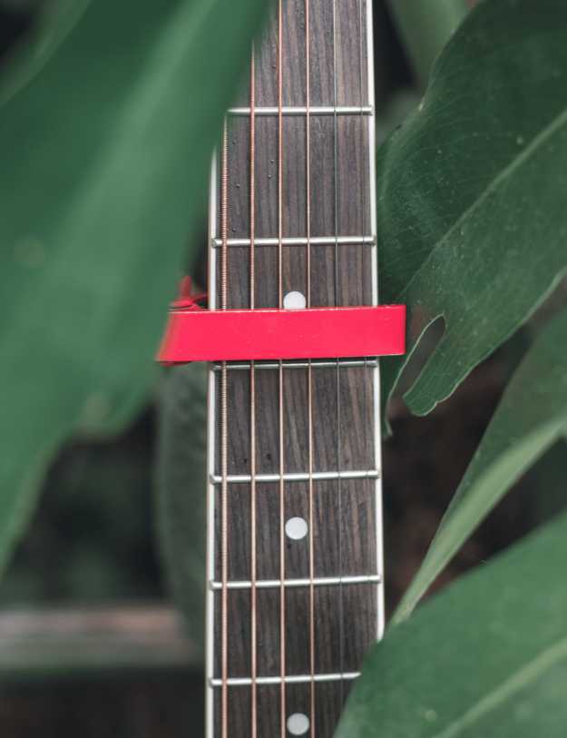 Close up of a capo on someones guitar.