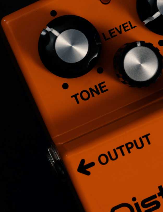 Close up of a orange guitar pedal.