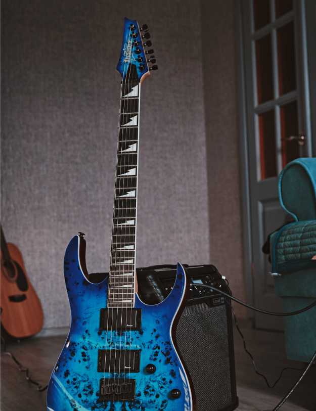A blue Ibanez guitar set up against an amp.