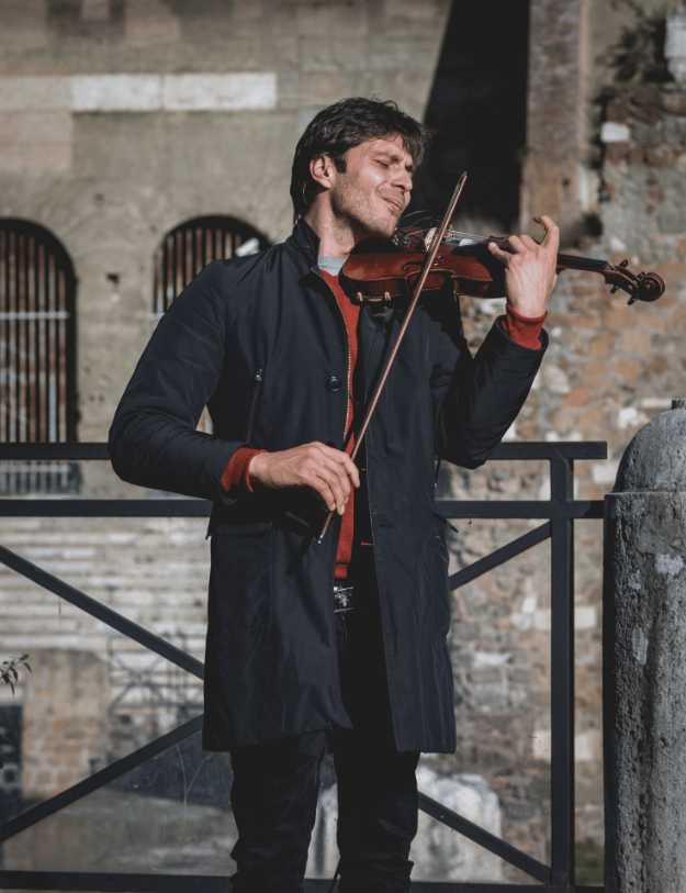 Man playing the violin outside.