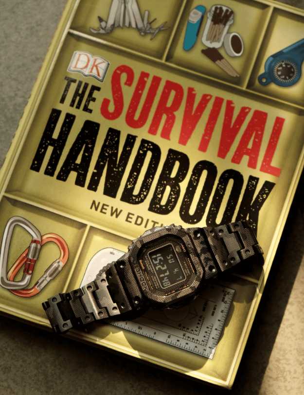 A survival watch sitting on top of a survival book.