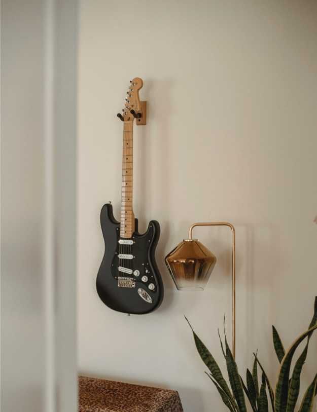 A guitar mounted on a wall with decorations around it.