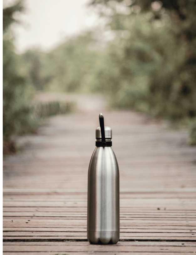 A stainless steel water bottle on a bridge.