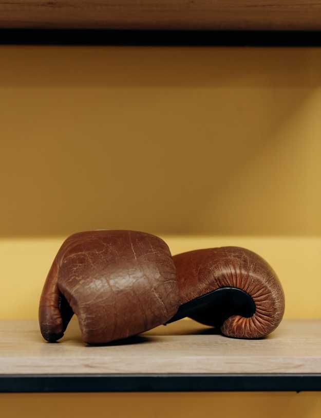 Used leather boxing gloves on table
