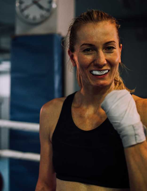 Woman with boxing mouthguard and handgrips on
