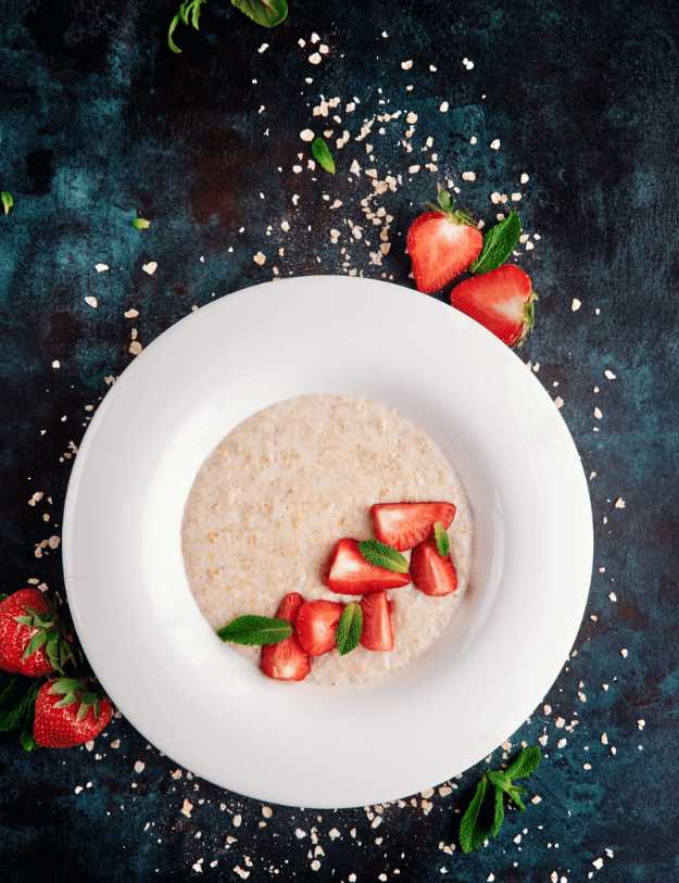 A delicious bowl of oatmeal with strawberries laid on top