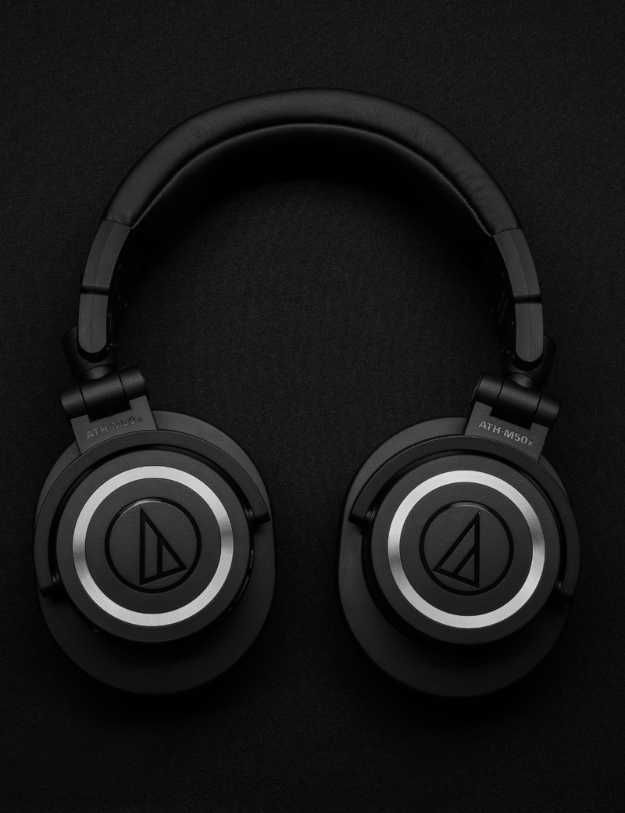 Headphones laying flat on a black surface.