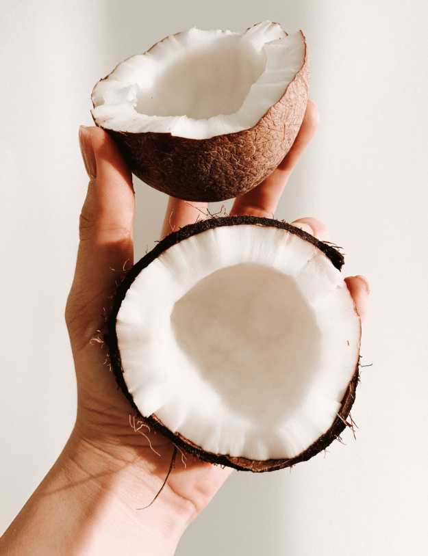 Someone holding an opened coconut.